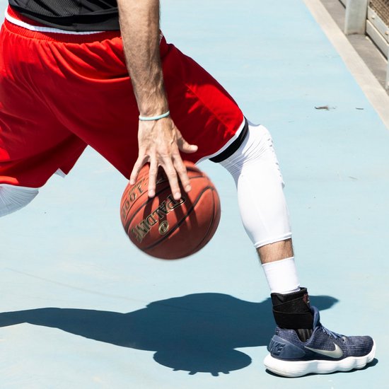 Basketballer aan het dribbelen met enkelbrace, enkelbraces voor Basketbal