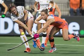 Dames die hockey spelen en een enkelbrace dragen.
