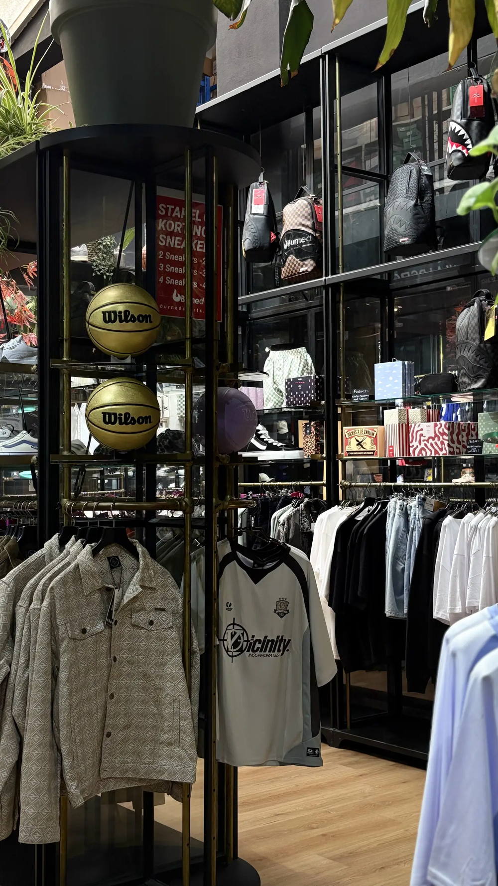 Wilson-basketballen en rekken met streetwear in de Burned Sports winkel in Den Bosch