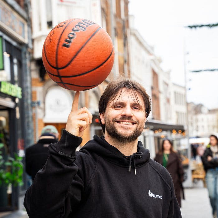 Een basketbal draait op een vinger in de Hinthamerstraat, voor de winkel van Burned