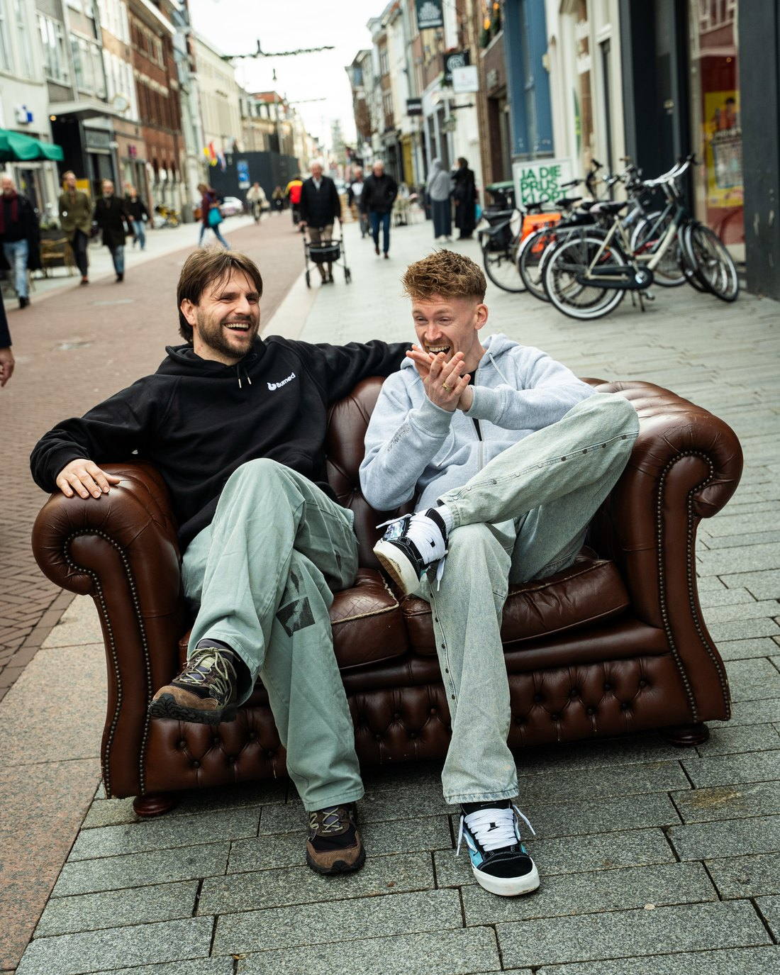Casper en Floris van Burned ontspannen op een chesterfield midden in de Hinthamerstraat
