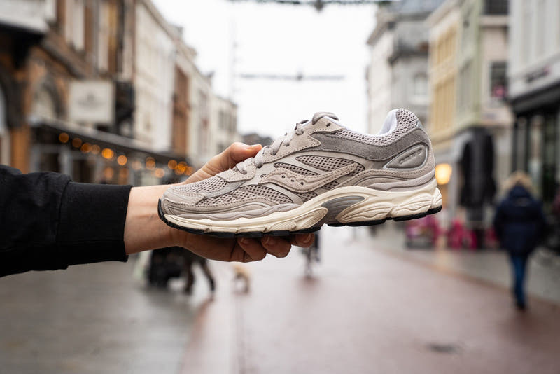 Een grijze sneaker op een uitgestrekte hand in de Hinthamerstraat