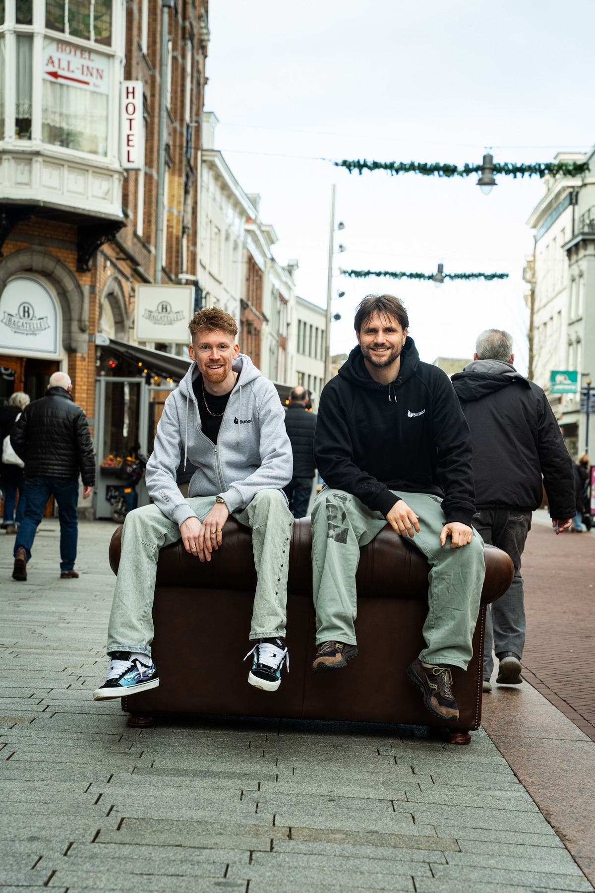 Casper en Floris van Burned op een chesterfield midden in de Hinthamerstraat