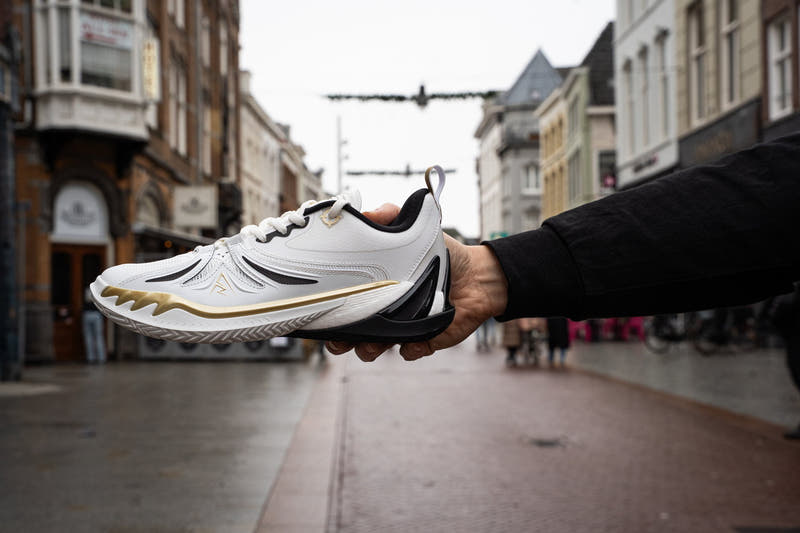 Een witte Rigorer AR3 basketbalschoen in de hand op de Hinthamerstraat in Den Bosch