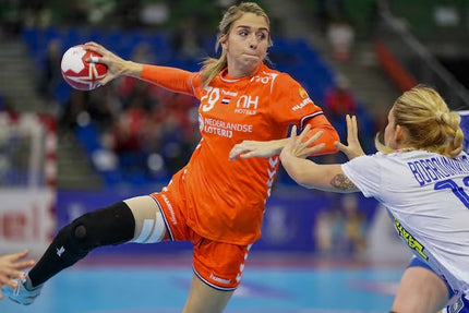 Een vrouw die met handbal een bal werpt op het doel en een brace draagt.