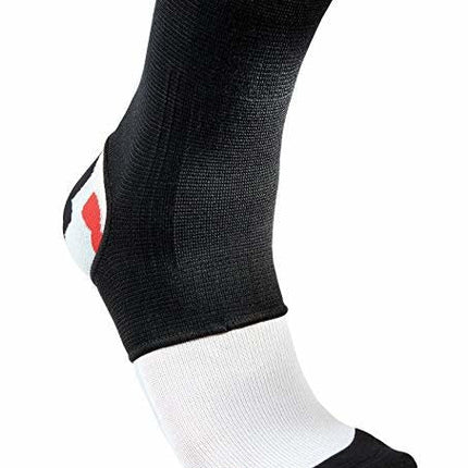 je ziet een onderbeen met een witte sok en een goedkope zwarte elastische enkelbrace