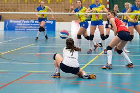Dames die volleybal spelen en een enkelbrace dragen.