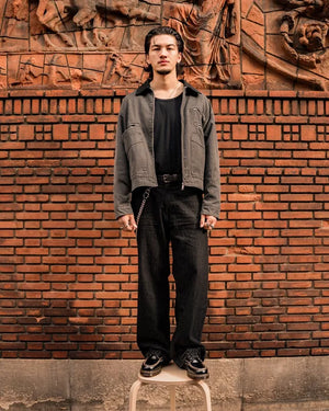Dr. Martens Lowell zwart, gedragen door een model tegen een bakstenen muur.