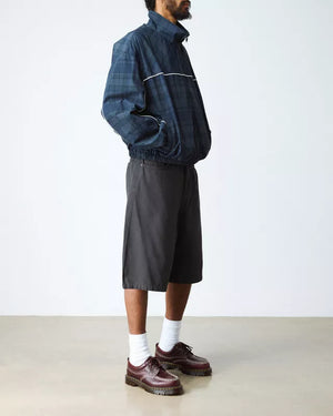 Dr. Martens Lowell Cherry Red, gedragen door een model in een trainingsjack.