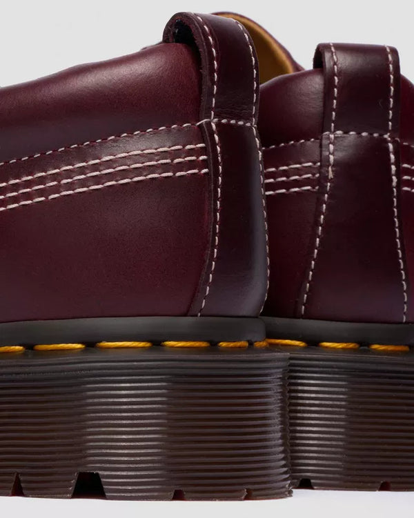 Dr. Martens Lowell Cherry Red, close-up van hiel en AirWair-zool.