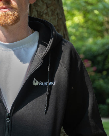 Burned Joggingpak zwart close up linkerschouder borduursel zipvest