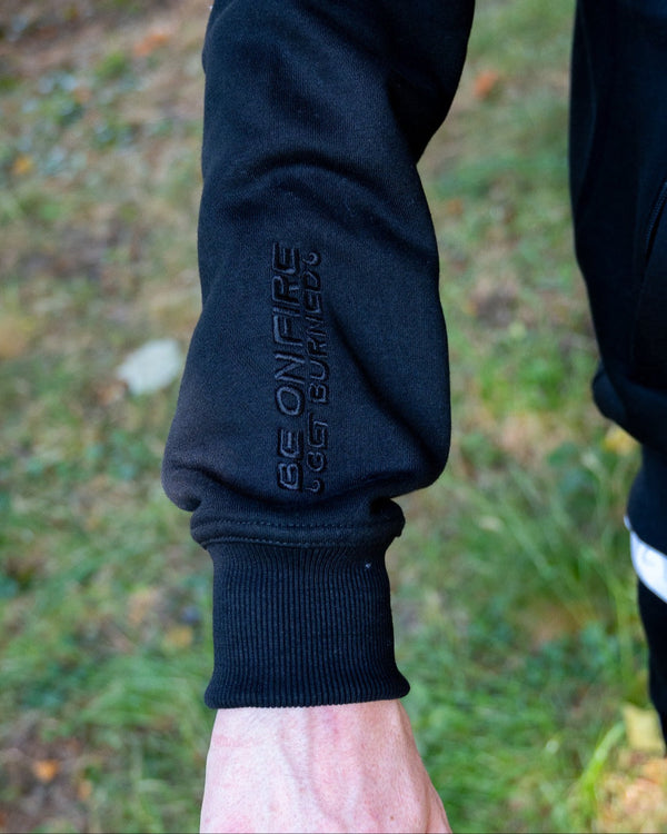 Burned Joggingpak zwart close up rechtermouw borduursel zip hoodie vest