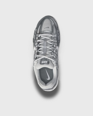 Nike P-6000 sneaker in wit en zilver met retro hardloopdesign, ademend mesh bovenwerk en comfortabele demping. Verkrijgbaar bij Burned Sports Den Bosch, dé specialist in sneakers, basketbal- en sportartikelen.