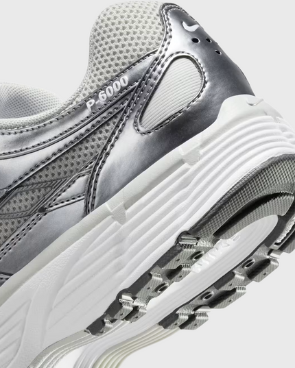 Nike P-6000 sneaker in wit en zilver met retro hardloopdesign, ademend mesh bovenwerk en comfortabele demping. Verkrijgbaar bij Burned Sports Den Bosch, dé specialist in sneakers, basketbal- en sportartikelen.