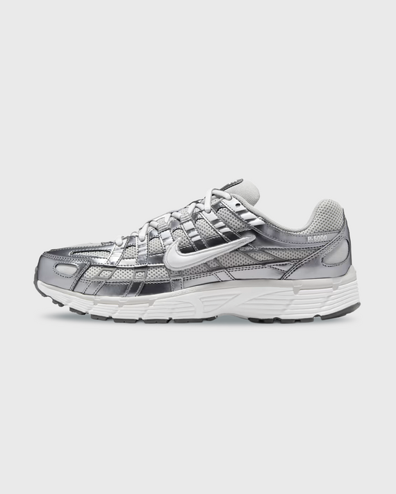 Nike P-6000 sneaker in wit en zilver met retro hardloopdesign, ademend mesh bovenwerk en comfortabele demping. Verkrijgbaar bij Burned Sports Den Bosch, dé specialist in sneakers, basketbal- en sportartikelen.
