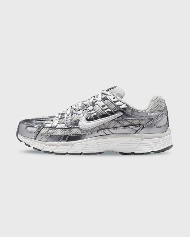 Nike P-6000 sneaker in wit en zilver met retro hardloopdesign, ademend mesh bovenwerk en comfortabele demping. Verkrijgbaar bij Burned Sports Den Bosch, dé specialist in sneakers, basketbal- en sportartikelen.