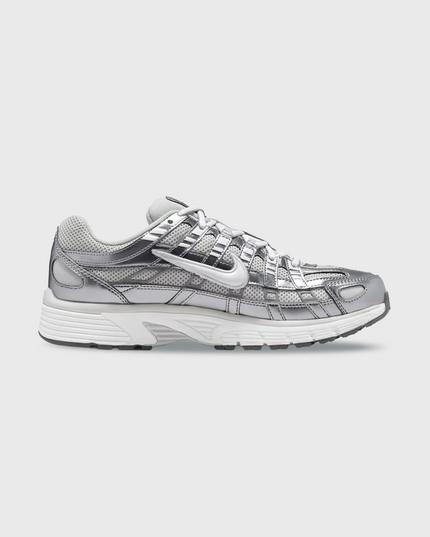Nike P-6000 sneaker in wit en zilver met retro hardloopdesign, ademend mesh bovenwerk en comfortabele demping. Verkrijgbaar bij Burned Sports Den Bosch, dé specialist in sneakers, basketbal- en sportartikelen.