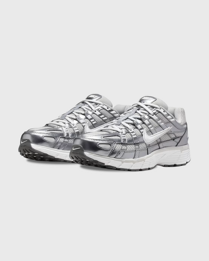 Nike P-6000 sneaker in wit en zilver met retro hardloopdesign, ademend mesh bovenwerk en comfortabele demping. Verkrijgbaar bij Burned Sports Den Bosch, dé specialist in sneakers, basketbal- en sportartikelen.