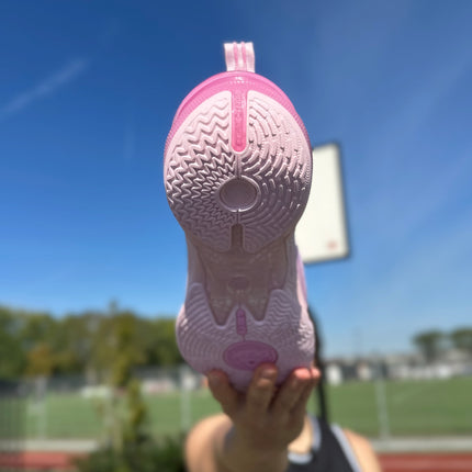 PEAK Flash 6 Basketbalschoen Roze Zoolaanzicht word vastgehouden door man met basketbal veld in achtergrond