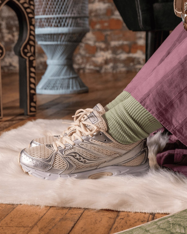 Saucony Ride Millennium Sneaker Cream / Zilver on feet in cosy room