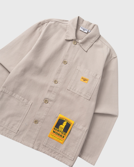 Service Works Canvas Chore Shirt Grijs overall aanzicht schuin met label en etiket geel oranje service works logo