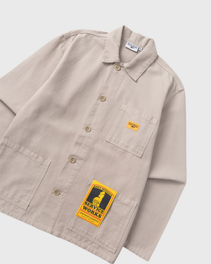 Service Works Canvas Chore Shirt Grijs overall aanzicht schuin met label en etiket geel oranje service works logo
