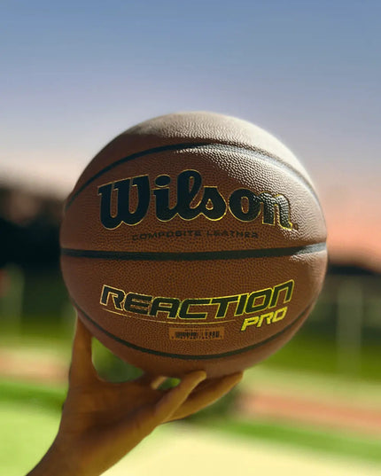 Wilson Reaction Pro Basketbal Indoor _ Outdoor Maat 5,6 & 7 by Burned Sports met Blauw basketbalveld lichte achtergrond