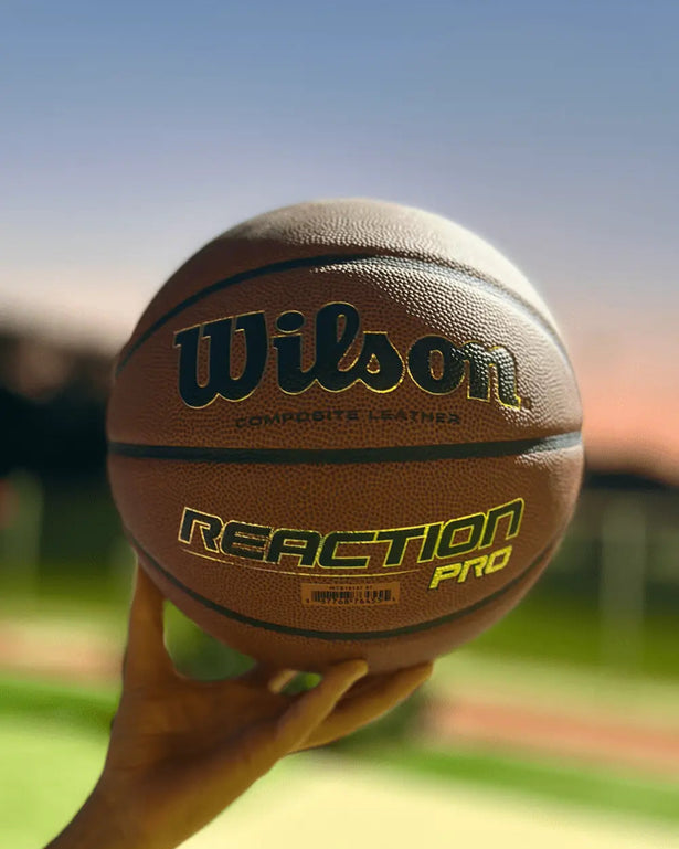 Wilson Reaction Pro Basketbal Indoor _ Outdoor Maat 5,6 & 7 by Burned Sports met Blauw basketbalveld lichte achtergrond