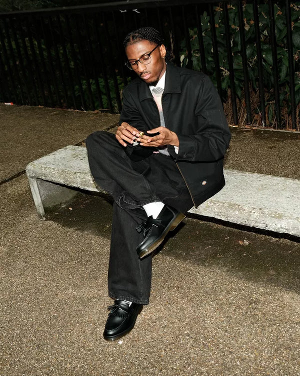Dr. Martens Adrian Polished Loafer zwart, gedragen door een model, zittend.