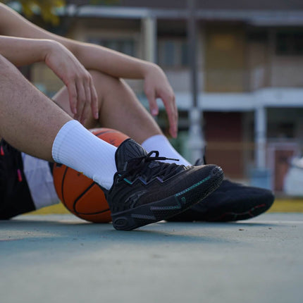 anta kai 2 triple black basketbalschoenen on feet sitting with basketbal