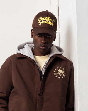 Goodies Sportive Memory Jacket bruin, gedragen door een model over een grijze hoodie, close-up.