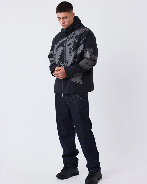 Project X Paris Tag Stiksel Jeans, gedragen onder een grafisch windjack, vooraanzicht.