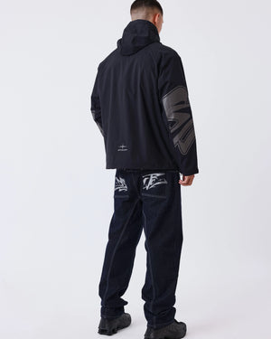 Project X Paris Tag Stiksel Jeans, gedragen onder een windjack, achteraanzicht met tag-logo.