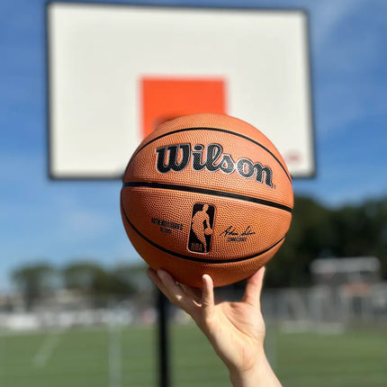 wilson buiten basketbal outdoor maat 7 6 5 heren kinderen dames authentic rubber buiten nba burned sportsop hand met zonlicht bij basketbalveld