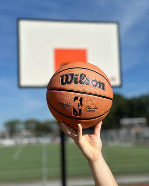 wilson buiten basketbal outdoor maat 7 6 5 heren kinderen dames authentic rubber buiten nba burned sportsop hand met zonlicht bij basketbalveld