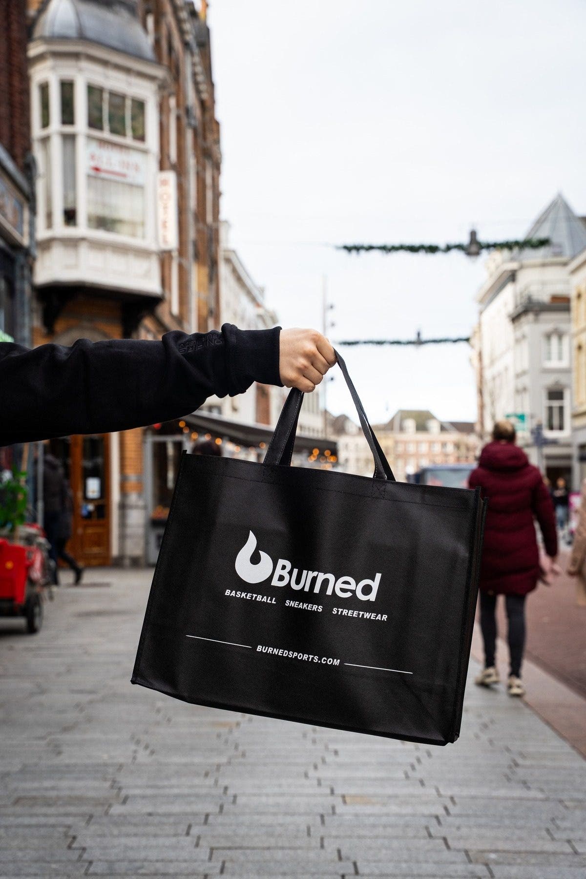 Een zwarte Burned-tas aan een uitgestrekte arm in de Hinthamerstraat
